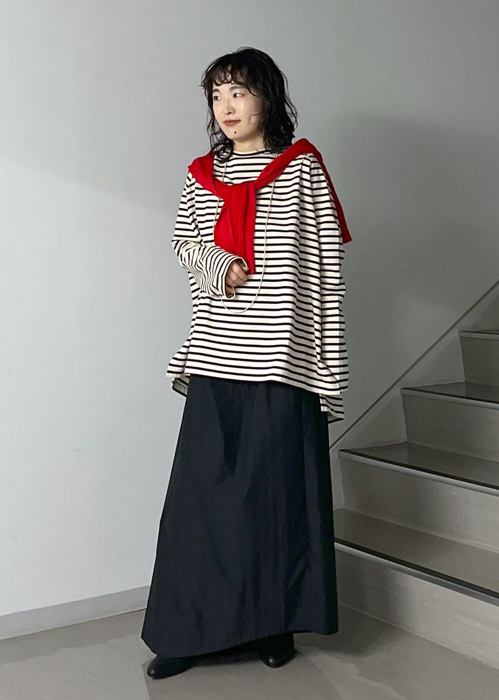 ブラック系のスカート、レッド系のカーディガン/ボレロ、ブラック系のショルダーバッグを着用したレディースの秋コーディネートの6枚目の写真