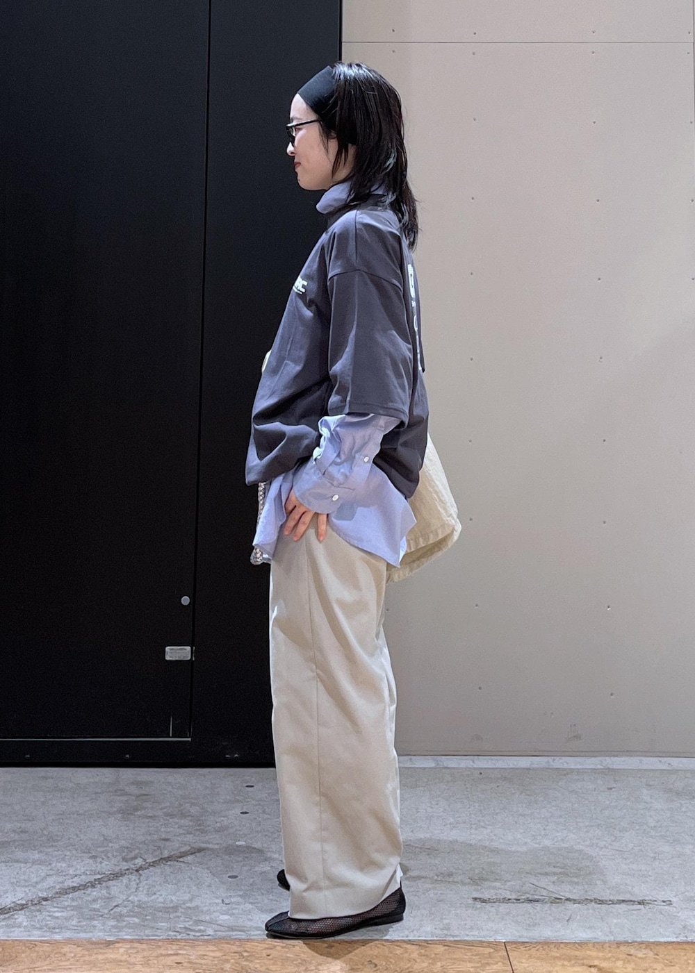 グレー系のスラックス、ベージュ系のブルゾン、ブラック系のパンプスを着用したレディースの春コーディネートの2枚目の写真