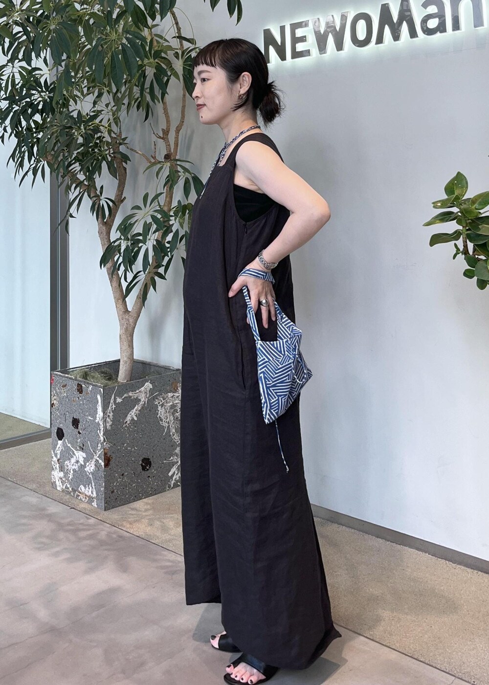 グレー系のカーディガン/ボレロ、ブラウン系のトートバッグ、ブラック系のジャンパースカートを着用したレディースの夏コーディネートの7枚目の写真