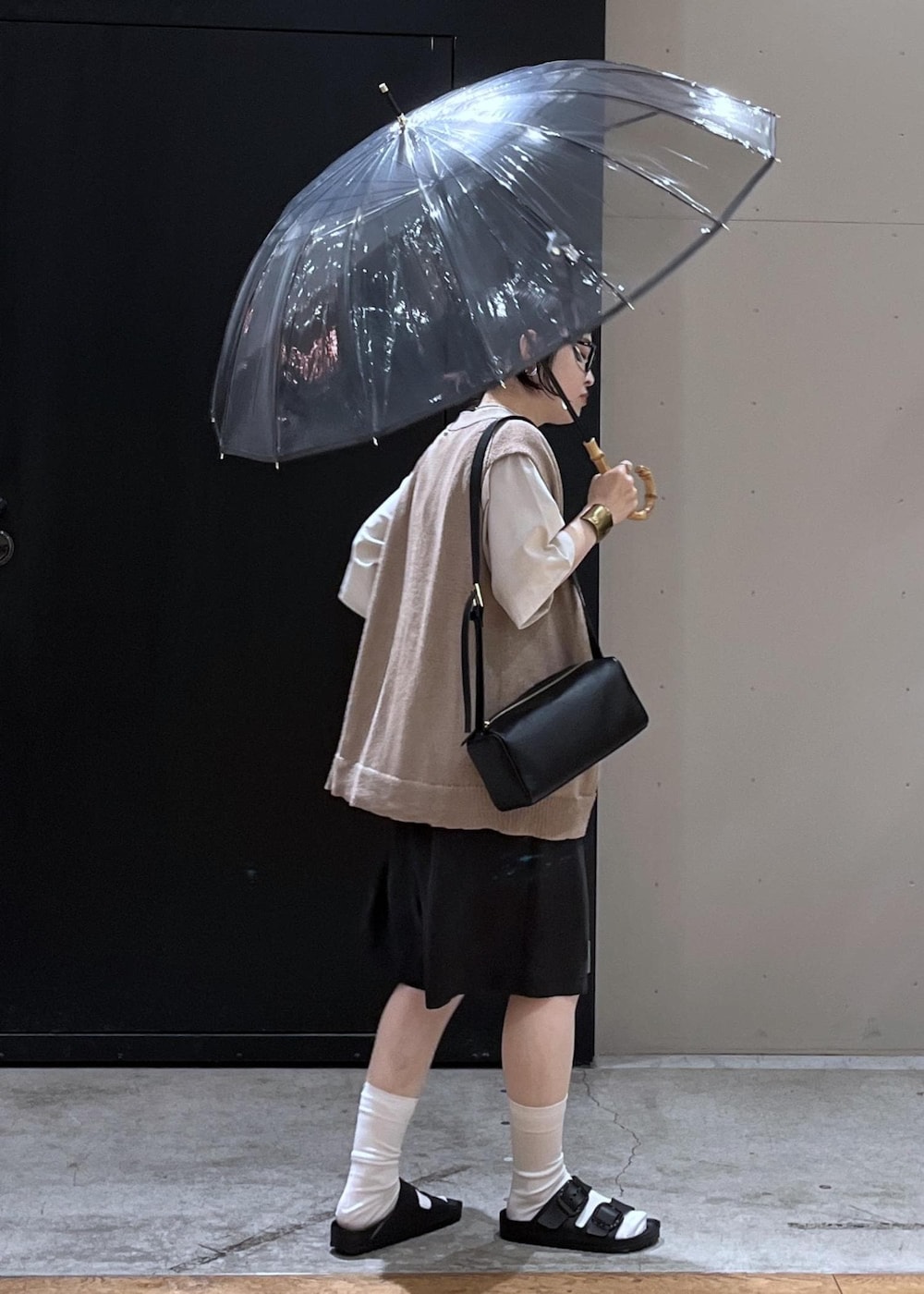 ブラック系のサンダル、ホワイト系のTシャツ/カットソー、ベージュ系のベストを着用したレディースの夏コーディネートの3枚目の写真