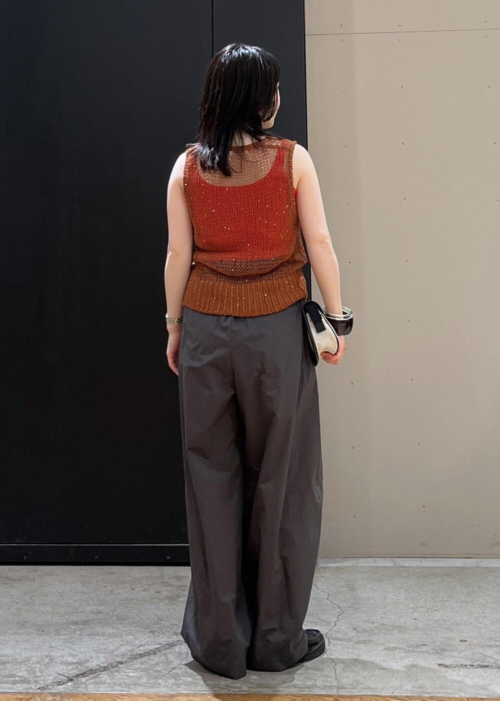 ホワイト系のショルダーバッグ、ブラック系のサンダル、レッド系のタンクトップを着用したレディースの春コーディネートの3枚目の写真