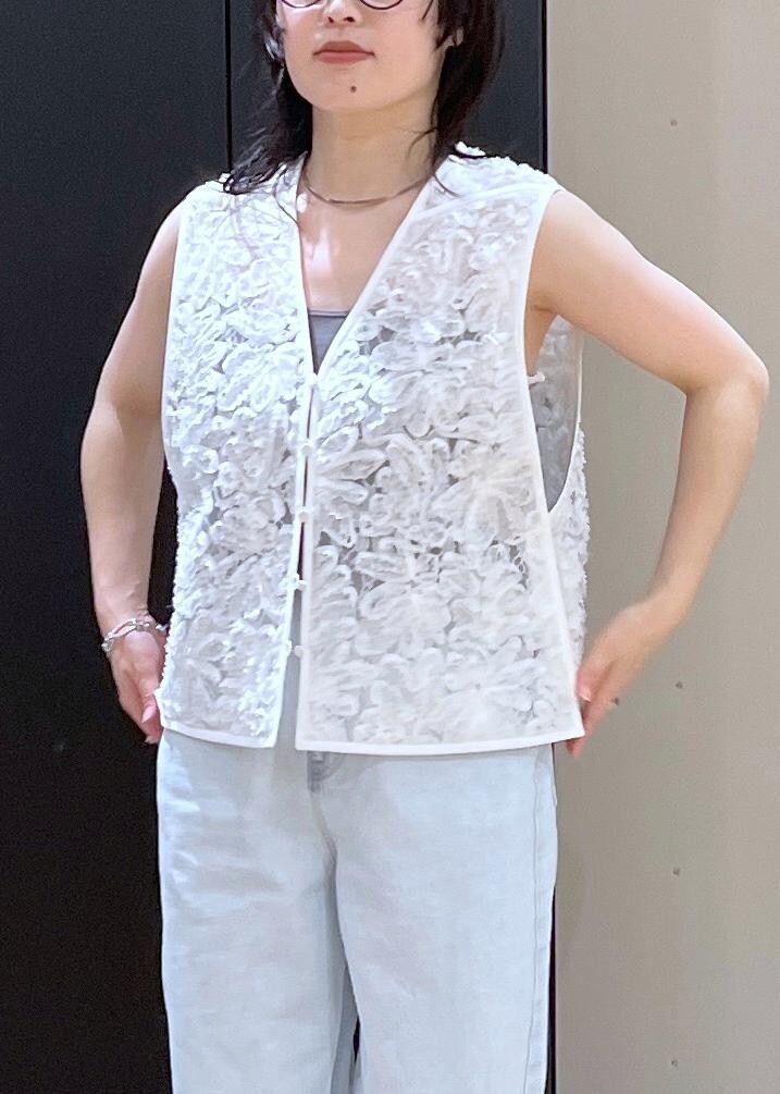 ベージュ系のボストンバッグ、ベージュ系のパンプス、ブルー系のデニムパンツを着用したレディースの冬コーディネートの4枚目の写真