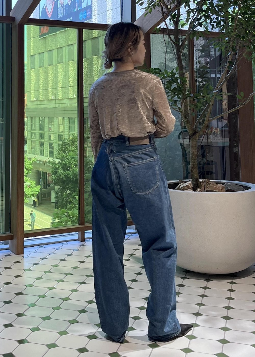 ベージュ系のショルダーバッグ、ブラック系のダウンジャケット/コート、ブルー系のデニムジャケットを着用したレディースの秋コーディネートの9枚目の写真