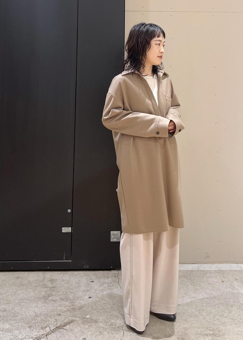 ブラック系のブーツ、イエロー系のワンピース、グレー系のブルゾンを着用したレディースの冬コーディネートの4枚目の写真