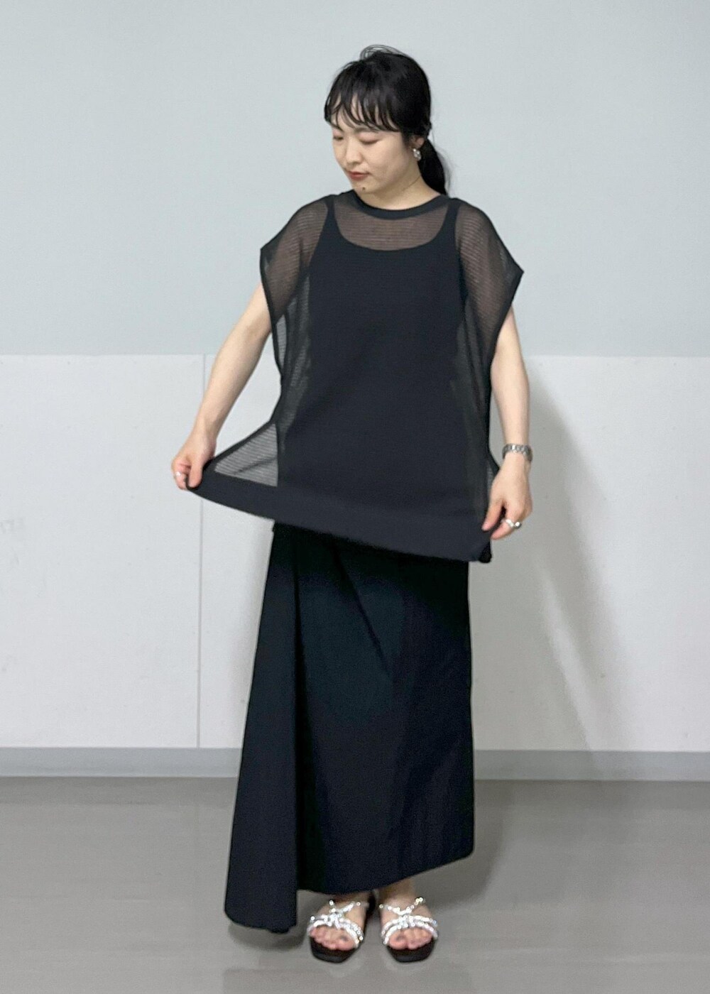 シルバー系のサンダル、ホワイト系のショルダーバッグ、ブラック系のタンクトップを着用したレディースの春コーディネートの4枚目の写真