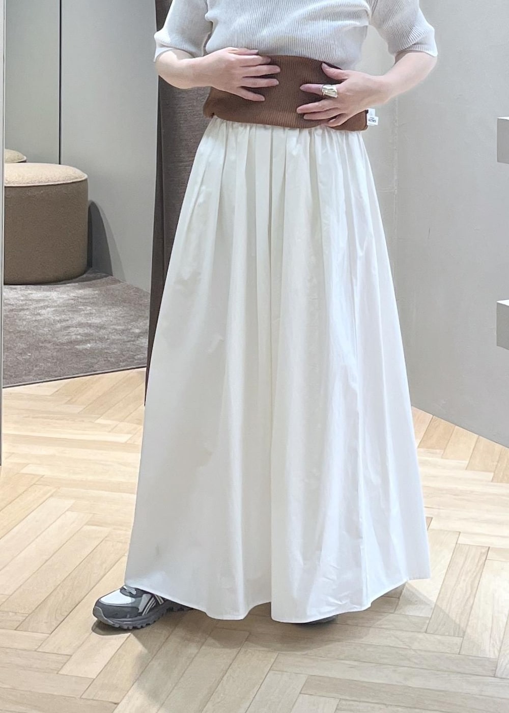 ホワイト系のブルゾン、ホワイト系のスカート、イエロー系のトートバッグを着用したレディースの春コーディネートの4枚目の写真