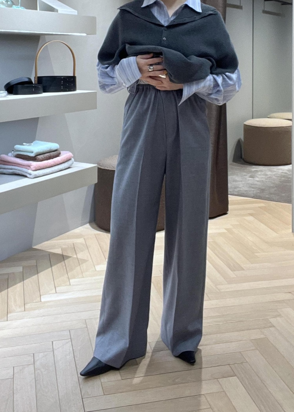 ブラック系のトートバッグ、ブラック系のブーツ、グレー系のニット/セーターを着用したレディースの冬コーディネートの4枚目の写真