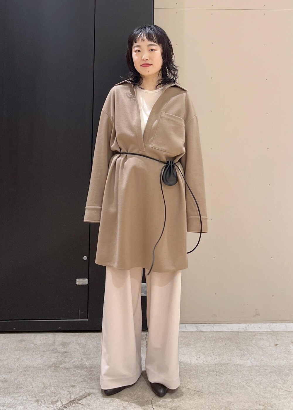 ブラック系のブーツ、イエロー系のワンピース、グレー系のブルゾンを着用したレディースの冬コーディネートの2枚目の写真