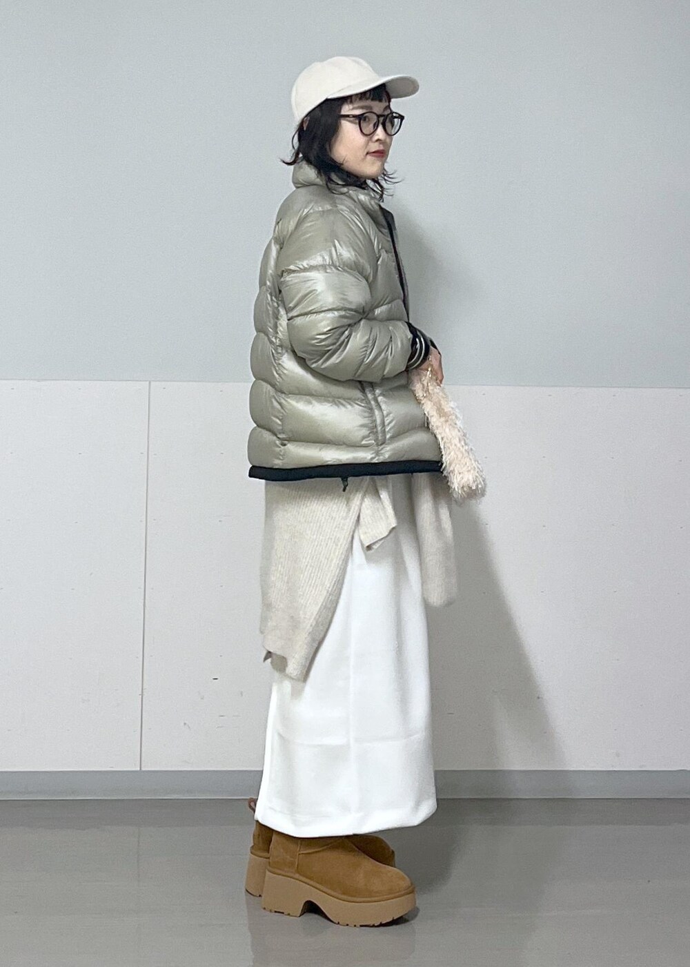 ホワイト系のカーディガン/ボレロ、ホワイト系のスカート、ホワイト系のTシャツ/カットソーを着用したレディースの冬コーディネートの3枚目の写真