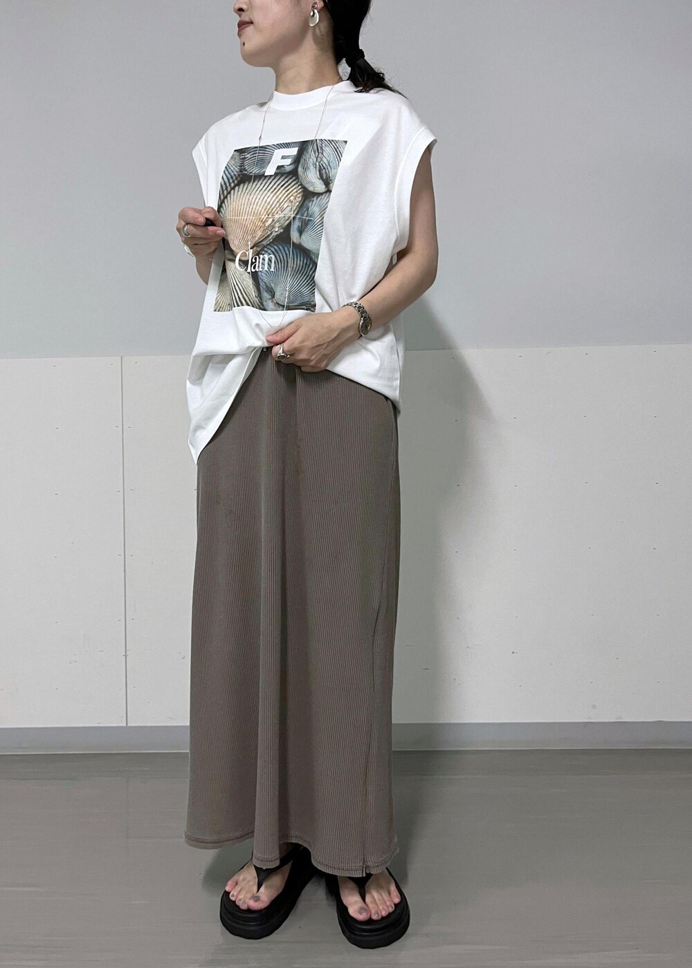 ブラック系のベスト、ホワイト系のTシャツ/カットソー、ブラック系のサンダルを着用したレディースの夏コーディネートの6枚目の写真