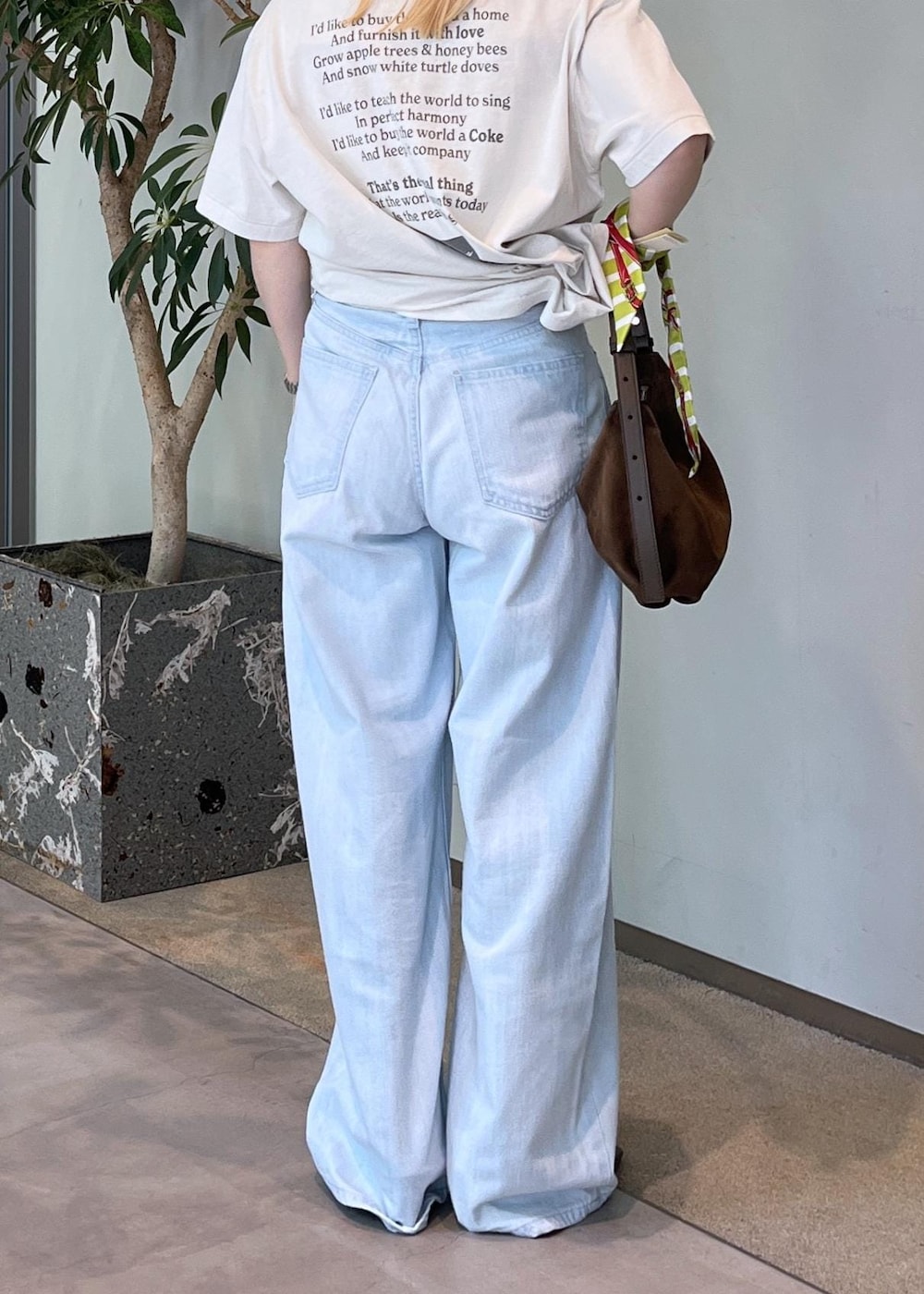 ブルー系のデニムパンツ、グリーン系のパンプス、ブラウン系のショルダーバッグを着用したレディースの夏コーディネートの8枚目の写真