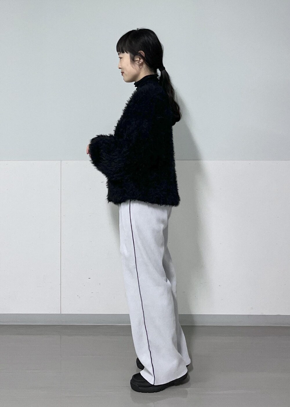 ブラック系のTシャツ/カットソー、ブラック系のモカシン/デッキシューズ、ホワイト系のカーディガン/ボレロを着用したレディースの冬コーディネートの4枚目の写真