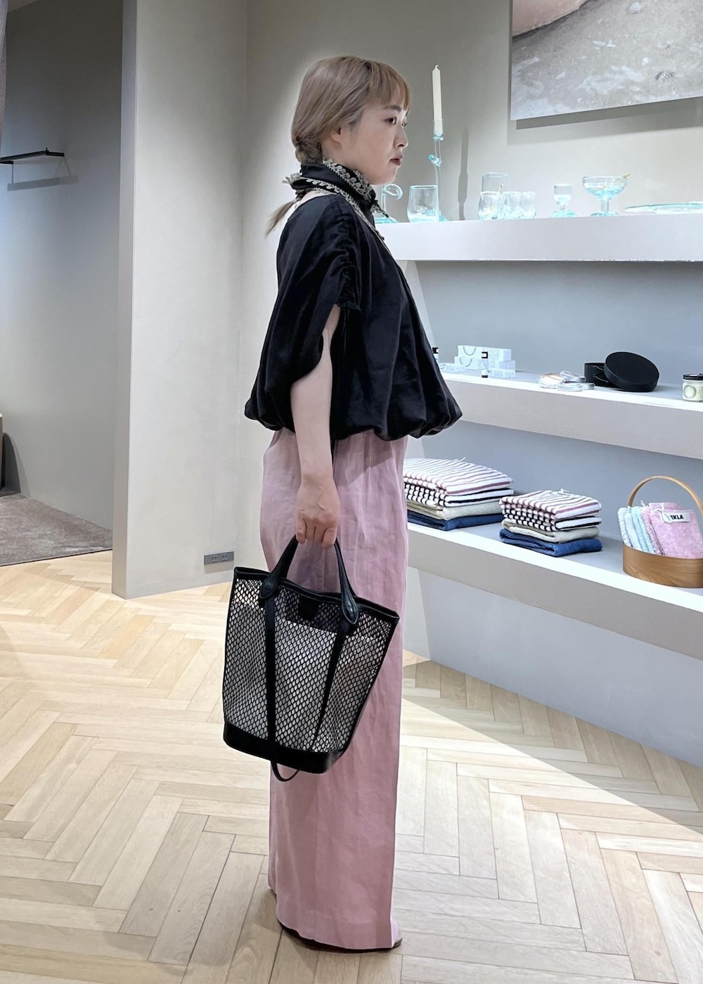 ピンク系のスラックス、ブラック系のトートバッグ、グレー系のシャツ/ブラウスを着用したレディースの春コーディネートの2枚目の写真