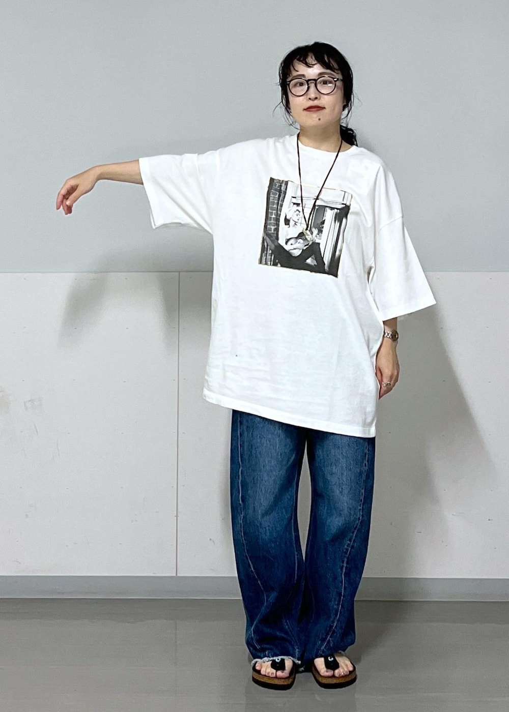 ブラック系のトートバッグ、ブルー系のデニムパンツ、ホワイト系のTシャツ/カットソーを着用したレディースの夏コーディネートの3枚目の写真