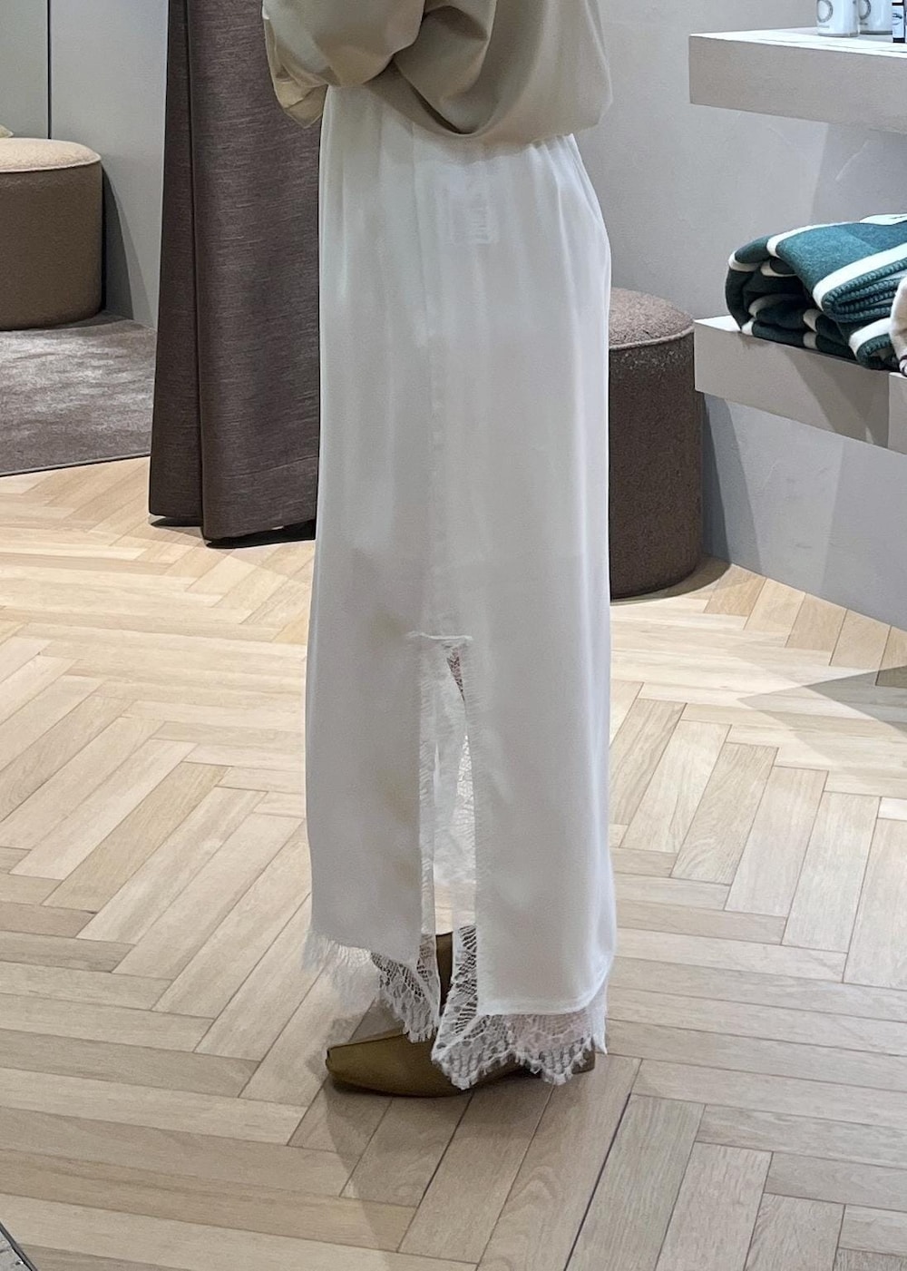 ベージュ系のスウェット、ブルー系のデニムパンツ、ホワイト系のスカートを着用したレディースの冬コーディネートの5枚目の写真