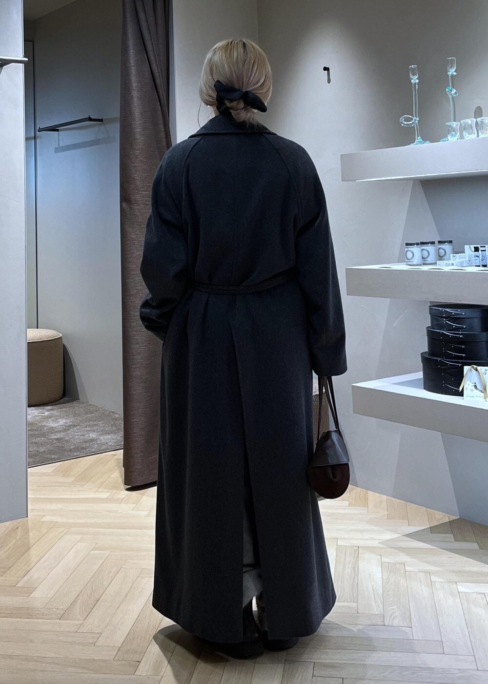 ブラック系のブーツ、ベージュ系のカーディガン/ボレロ、グレー系のトレンチコートを着用したレディースの冬コーディネートの4枚目の写真