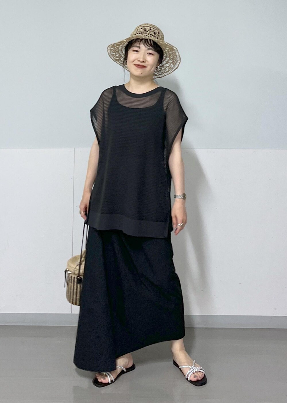 シルバー系のサンダル、ホワイト系のショルダーバッグ、ブラック系のタンクトップを着用したレディースの春コーディネートの2枚目の写真