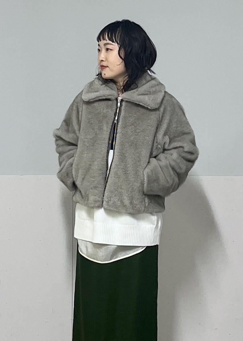 グリーン系のスカート、ホワイト系のシャツ/ブラウス、グレー系のブルゾンを着用したレディースの冬コーディネートの5枚目の写真