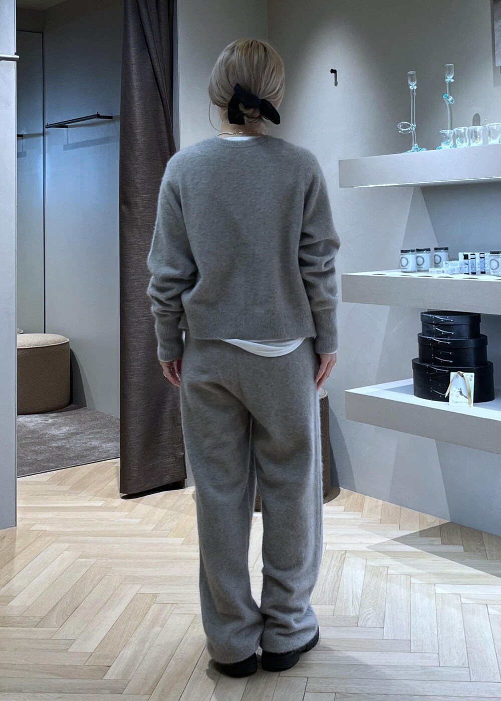 ブラック系のブーツ、ベージュ系のカーディガン/ボレロ、グレー系のトレンチコートを着用したレディースの冬コーディネートの6枚目の写真