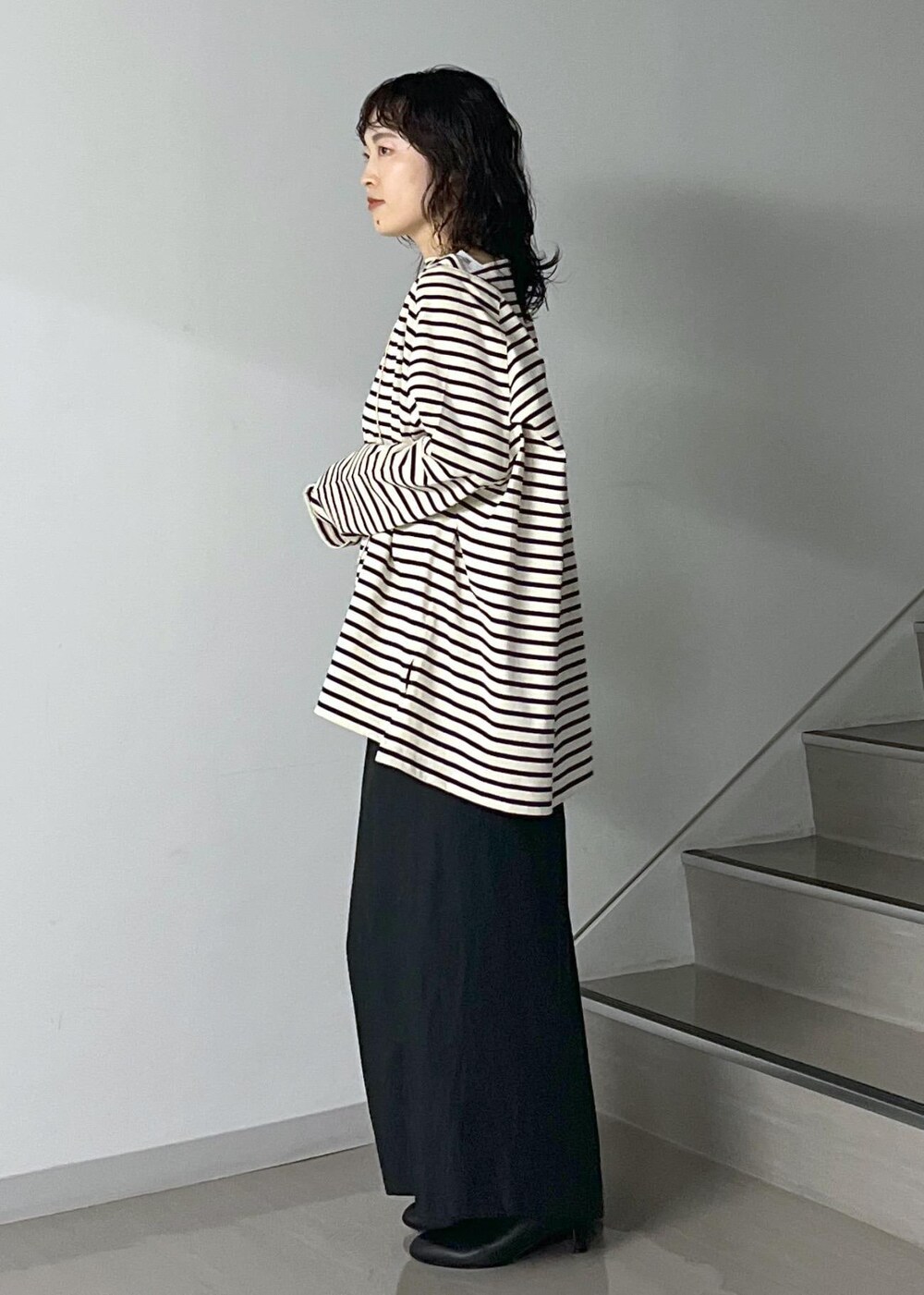 ブラック系のスカート、レッド系のカーディガン/ボレロ、ブラック系のショルダーバッグを着用したレディースの秋コーディネートの3枚目の写真