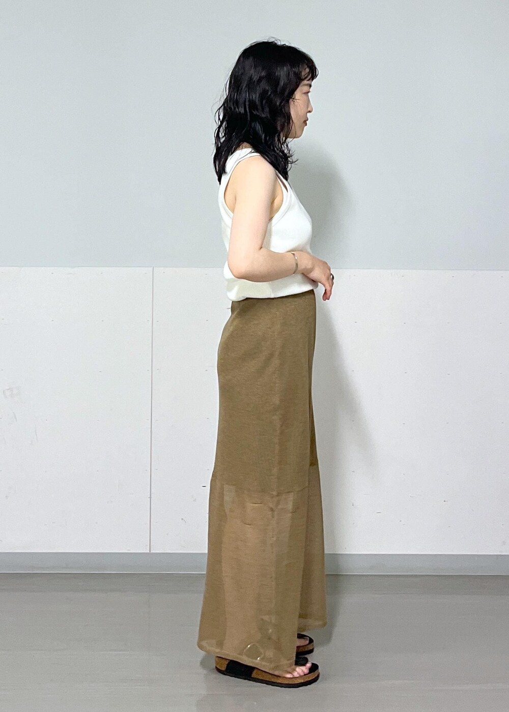 ベージュ系のTシャツ/カットソー、ゴールド系のスカート、イエロー系のバンダナ/スカーフを着用したレディースの夏コーディネートの8枚目の写真