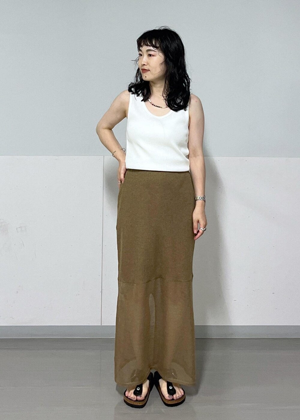 ベージュ系のTシャツ/カットソー、ゴールド系のスカート、イエロー系のバンダナ/スカーフを着用したレディースの夏コーディネートの6枚目の写真