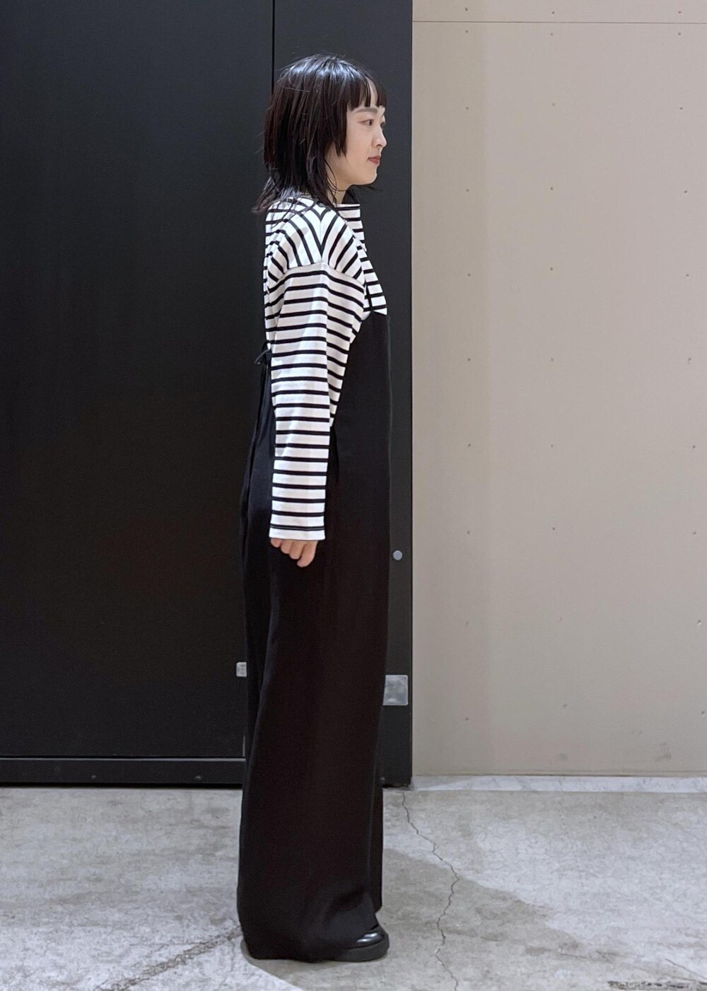 ベージュ系のボストンバッグ、ホワイト系のサロペット/オーバーオール、ホワイト系のマフラーを着用したレディースの冬コーディネートの3枚目の写真