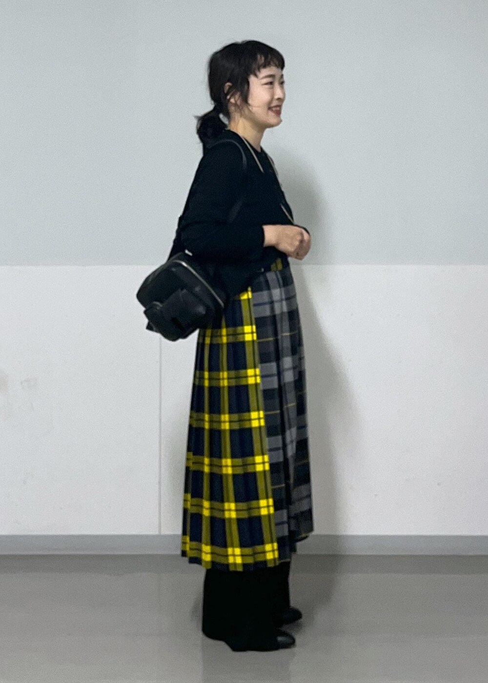 ブラック系のブーツ、グレー系のスカート、ブラック系のカーディガン/ボレロを着用したレディースの秋コーディネートの3枚目の写真