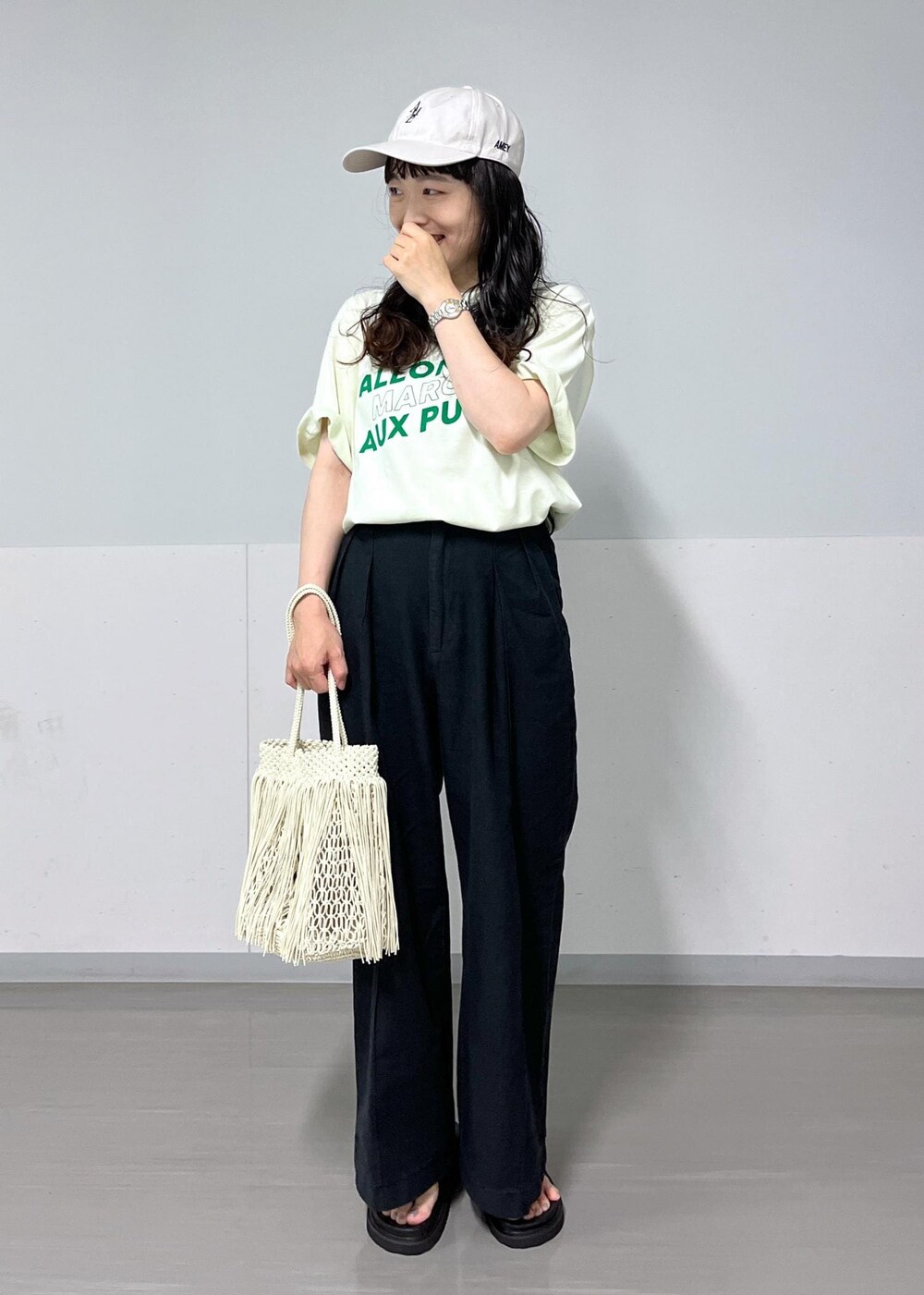 ブラック系のデニムパンツ、グリーン系のTシャツ/カットソー、ブラック系のサンダルを着用したレディースの夏コーディネートの3枚目の写真