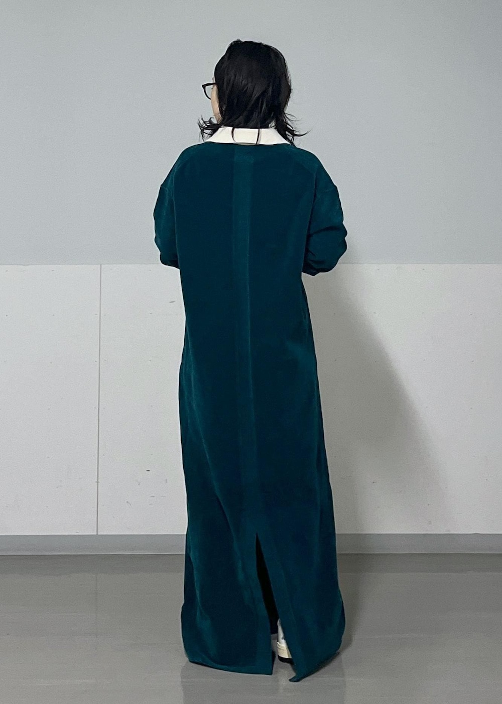 ホワイト系のハンドバッグ、ホワイト系のカーディガン/ボレロ、グリーン系のワンピースを着用したレディースの冬コーディネートの5枚目の写真