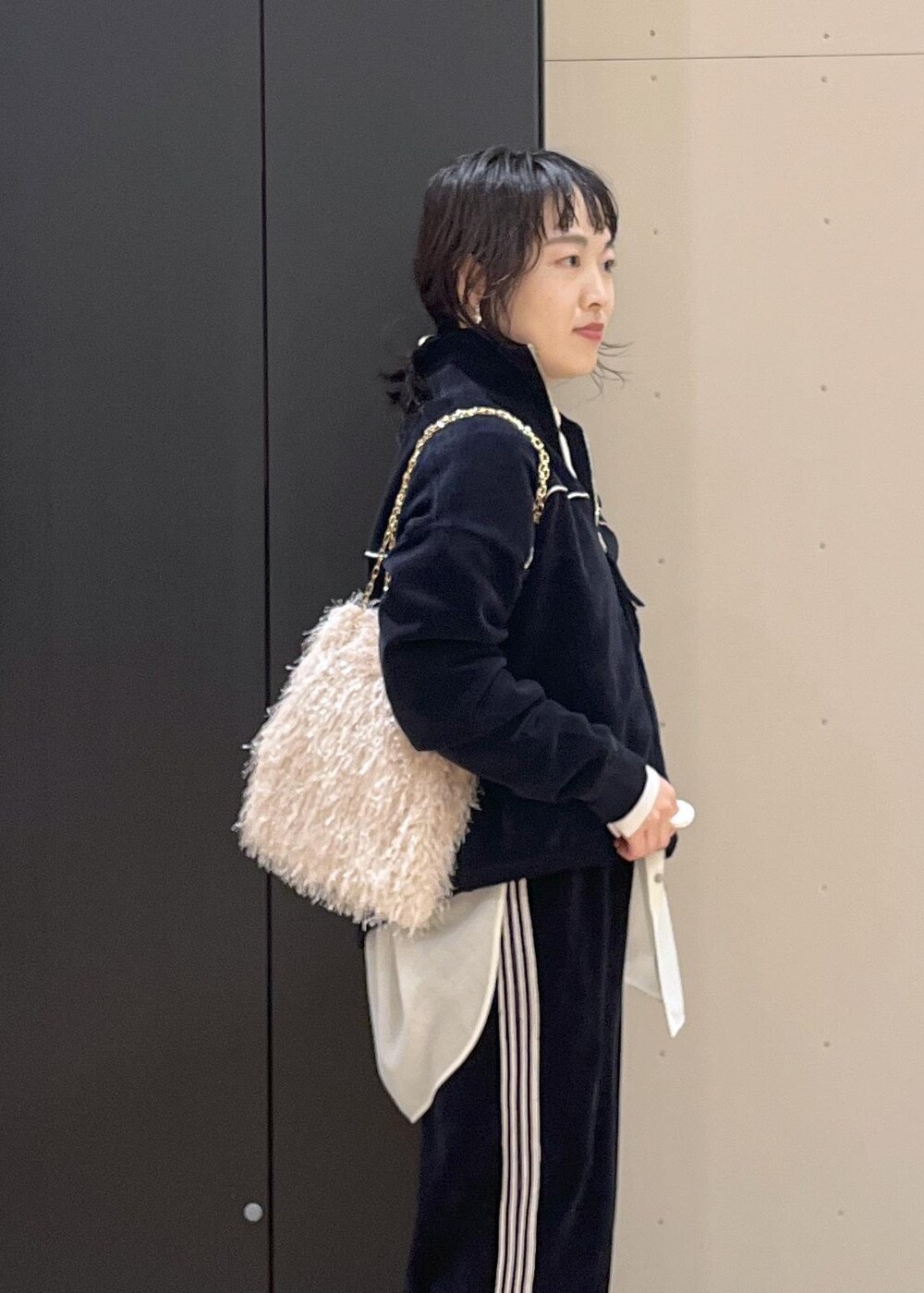 ブラック系のブーツ、ホワイト系のシャツ/ブラウス、ホワイト系のハンドバッグを着用したレディースの冬コーディネートの4枚目の写真