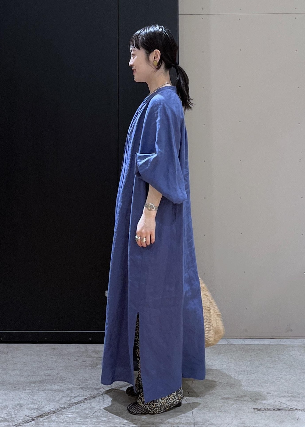 グレー系のその他パンツ、ホワイト系のかごバッグ、ブルー系のワンピースを着用したレディースの春コーディネートの2枚目の写真