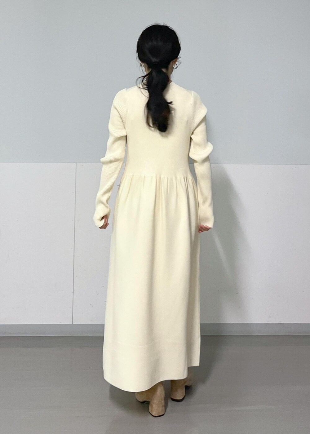 ブラウン系のブーツ、グレー系のMA-1、ホワイト系のワンピースを着用したレディースの冬コーディネートの9枚目の写真