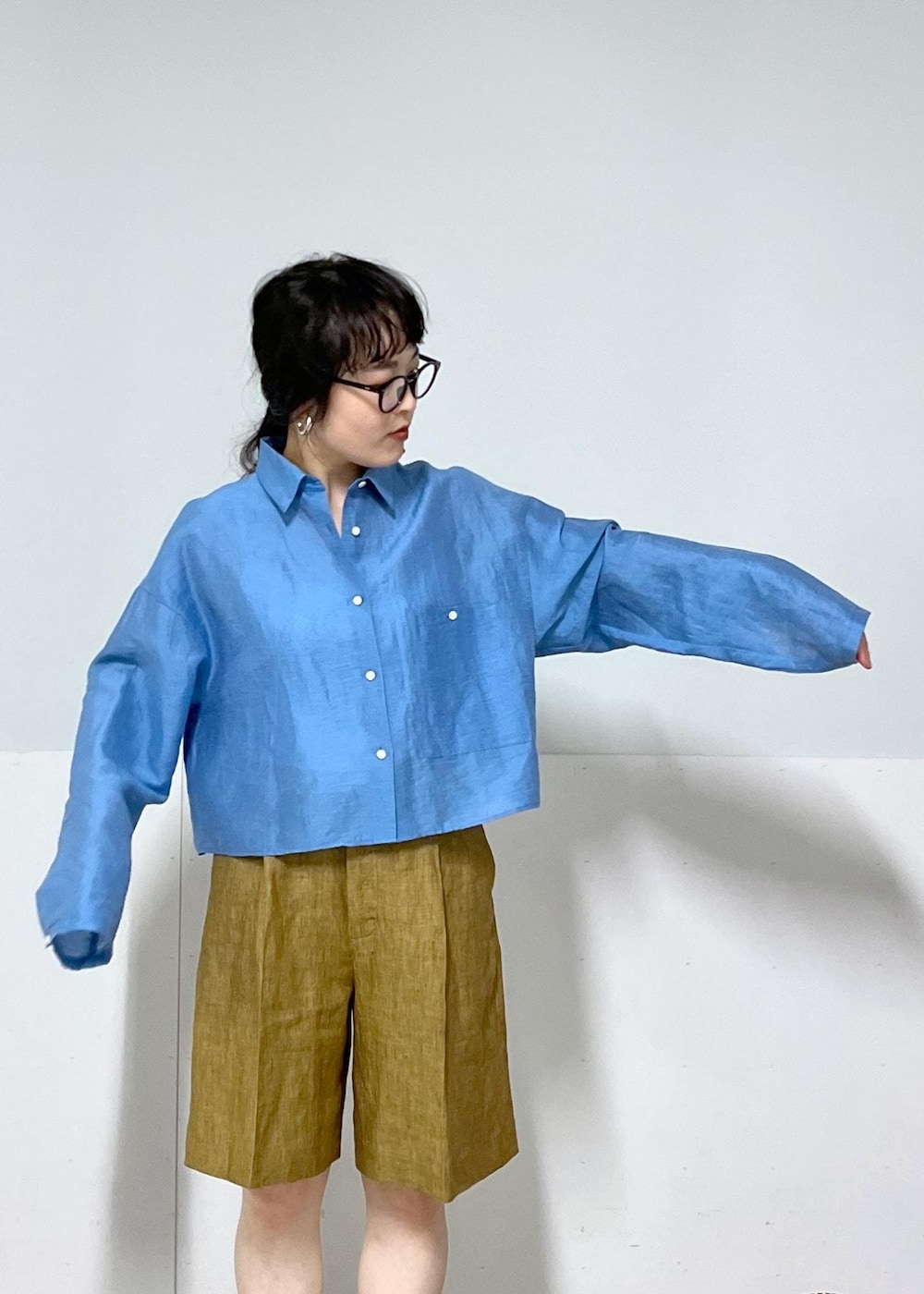 ホワイト系のサンダル、ベージュ系のかごバッグ、ブルー系のシャツ/ブラウスを着用したレディースの春コーディネートの4枚目の写真