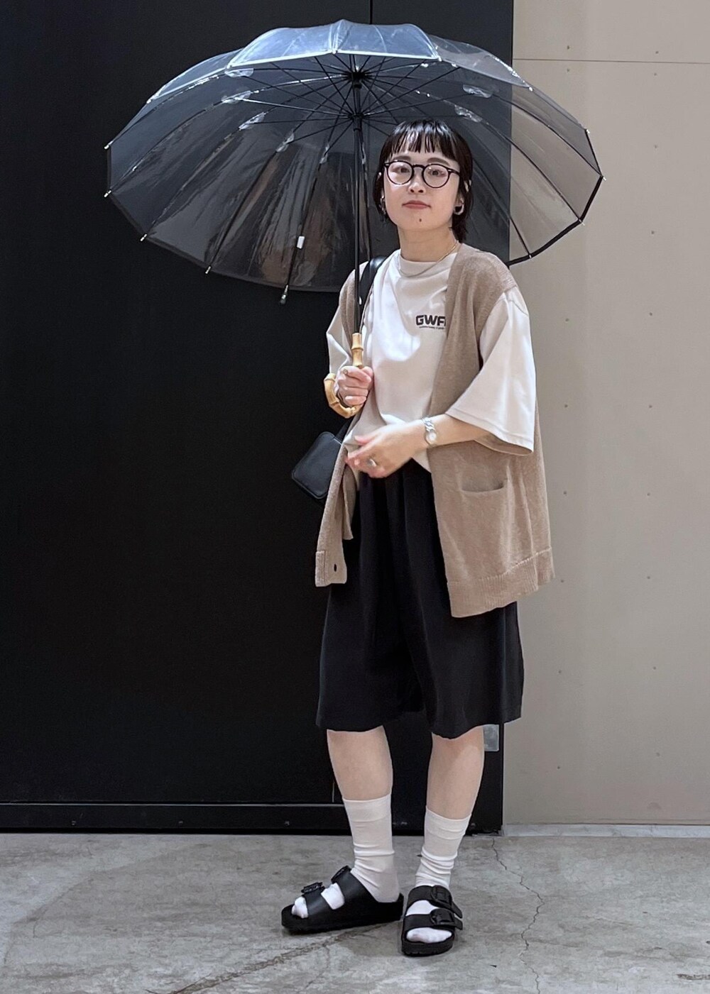 ブラック系のサンダル、ホワイト系のTシャツ/カットソー、ベージュ系のベストを着用したレディースの夏コーディネートの2枚目の写真