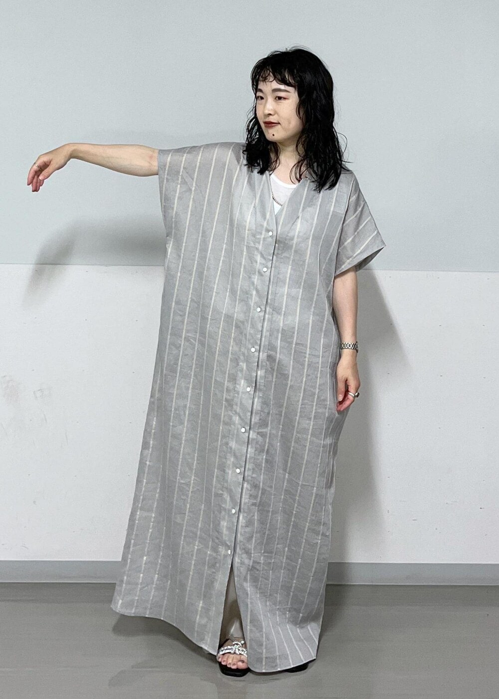 シルバー系のサンダル、ブルー系のワンピース、ベージュ系のその他パンツを着用したレディースの夏コーディネートの4枚目の写真