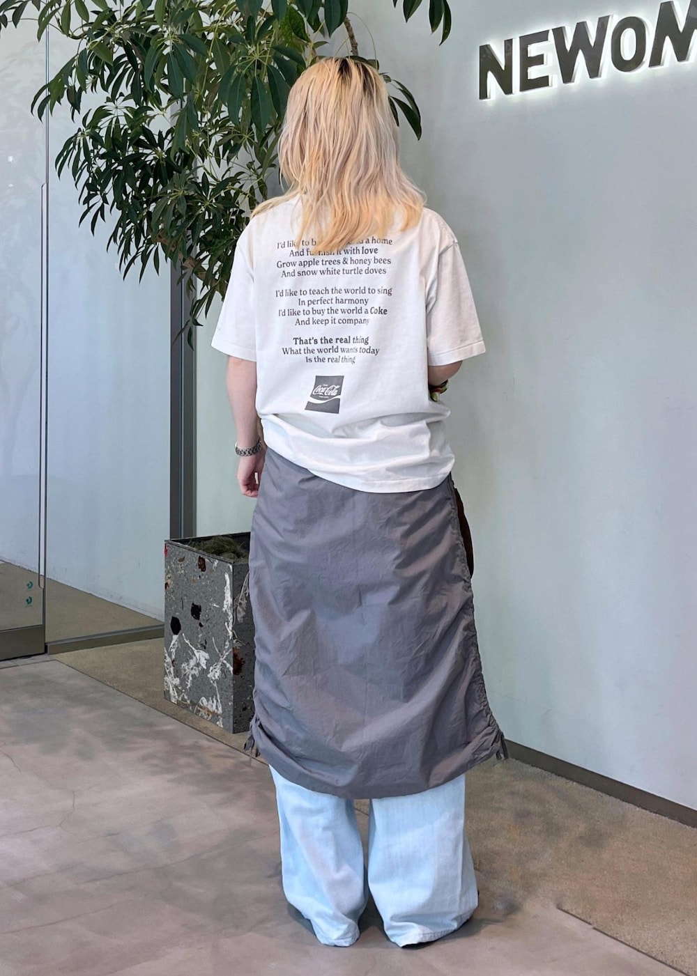 ブルー系のデニムパンツ、グリーン系のパンプス、ブラウン系のショルダーバッグを着用したレディースの夏コーディネートの3枚目の写真