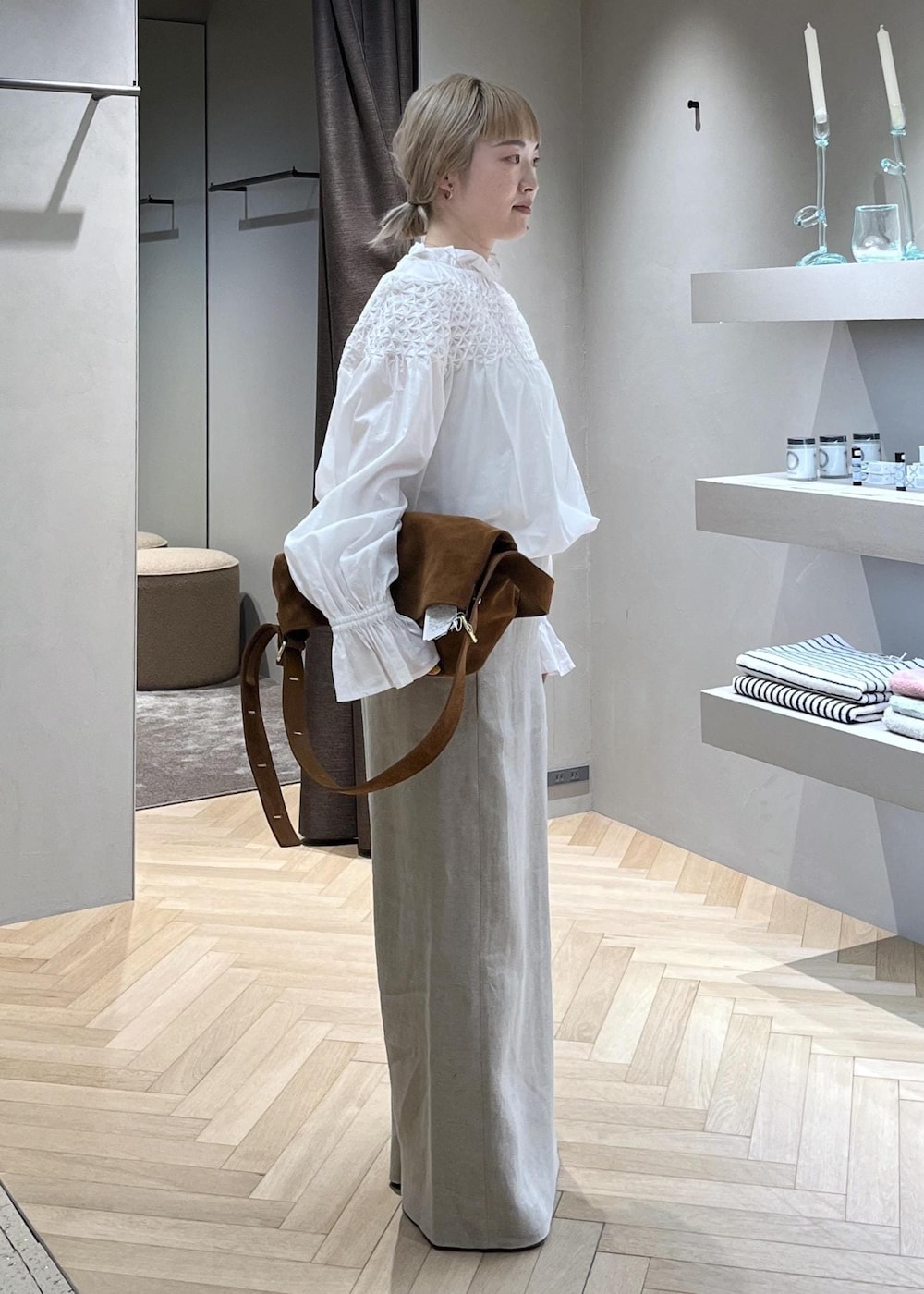 ベージュ系のスカート、ホワイト系のブルゾン、イエロー系のショルダーバッグを着用したレディースの春コーディネートの5枚目の写真