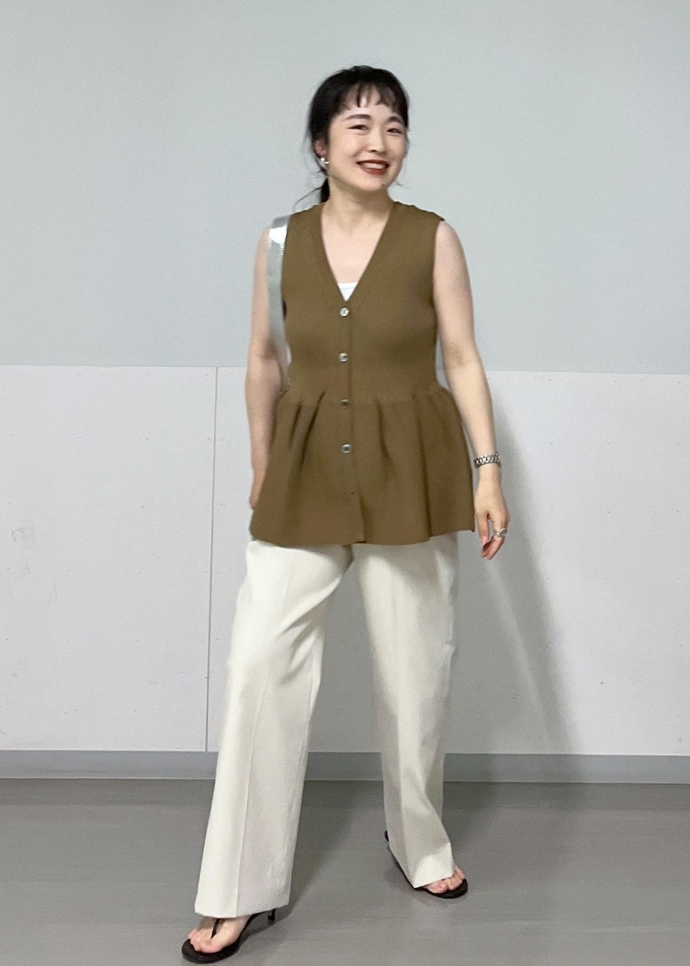 シルバー系のショルダーバッグ、ブラック系のサンダル、ホワイト系のその他パンツを着用したレディースの春コーディネートの2枚目の写真