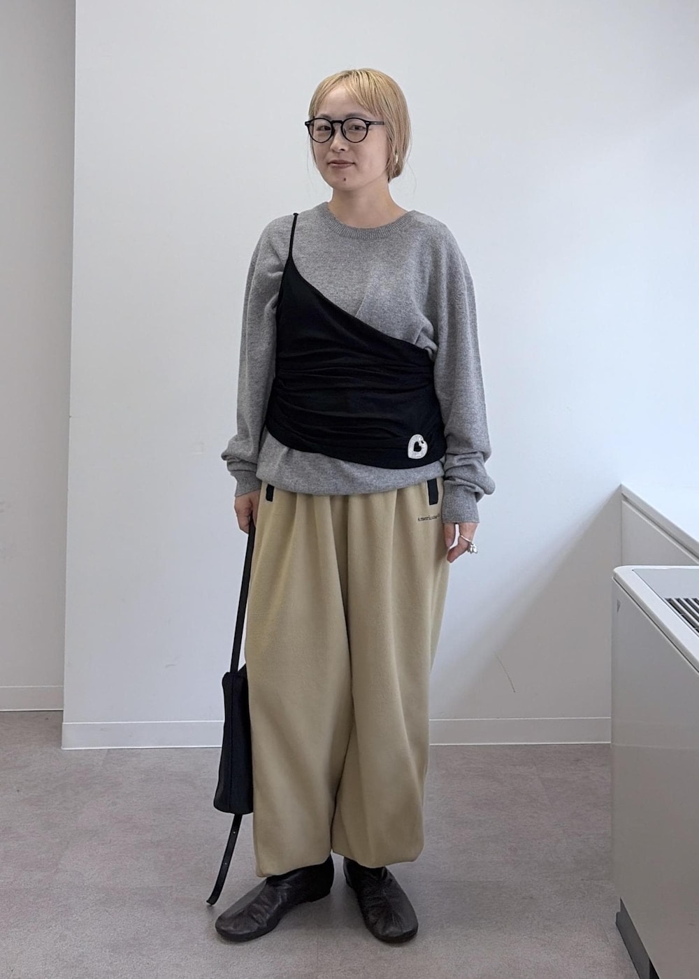ベージュ系のその他パンツ、グレー系のダウンジャケット/コート、ブラック系のショルダーバッグを着用したレディースの秋コーディネートの6枚目の写真