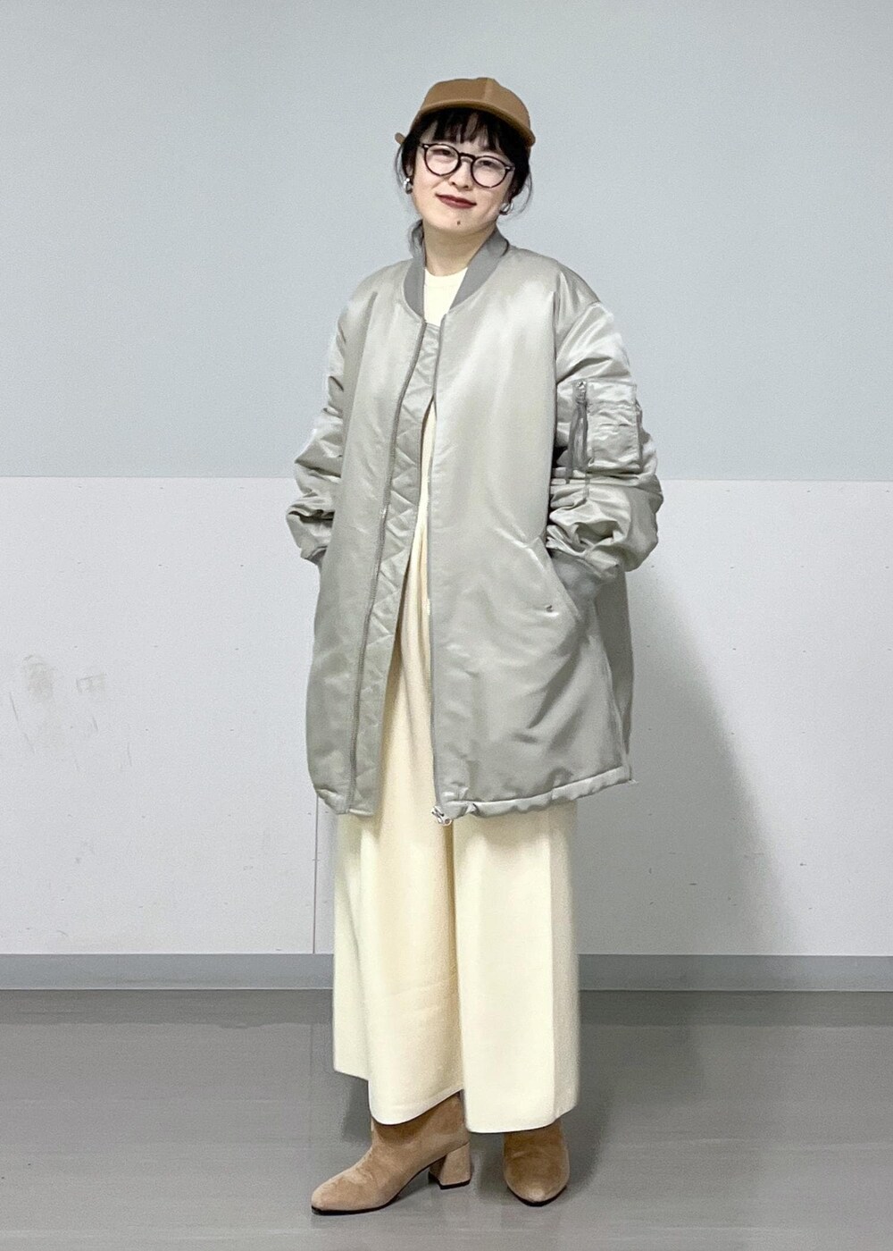 ブラウン系のブーツ、グレー系のMA-1、ホワイト系のワンピースを着用したレディースの冬コーディネートの3枚目の写真