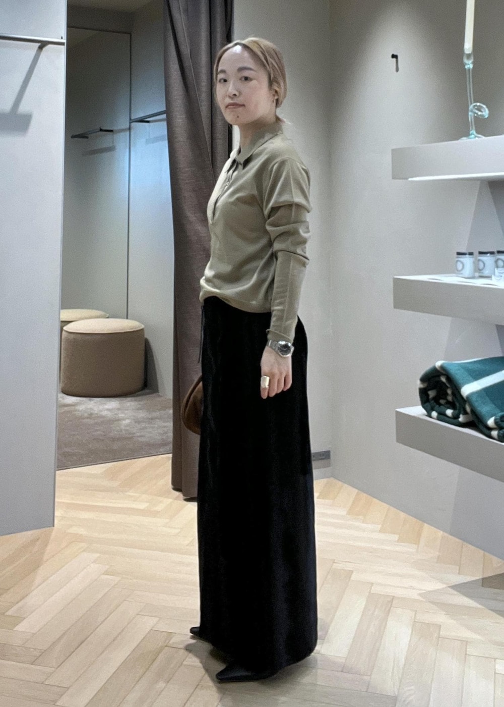 ブラック系のブーツ、ブラック系のスカート、ベージュ系のニット/セーターを着用したレディースの冬コーディネートの2枚目の写真