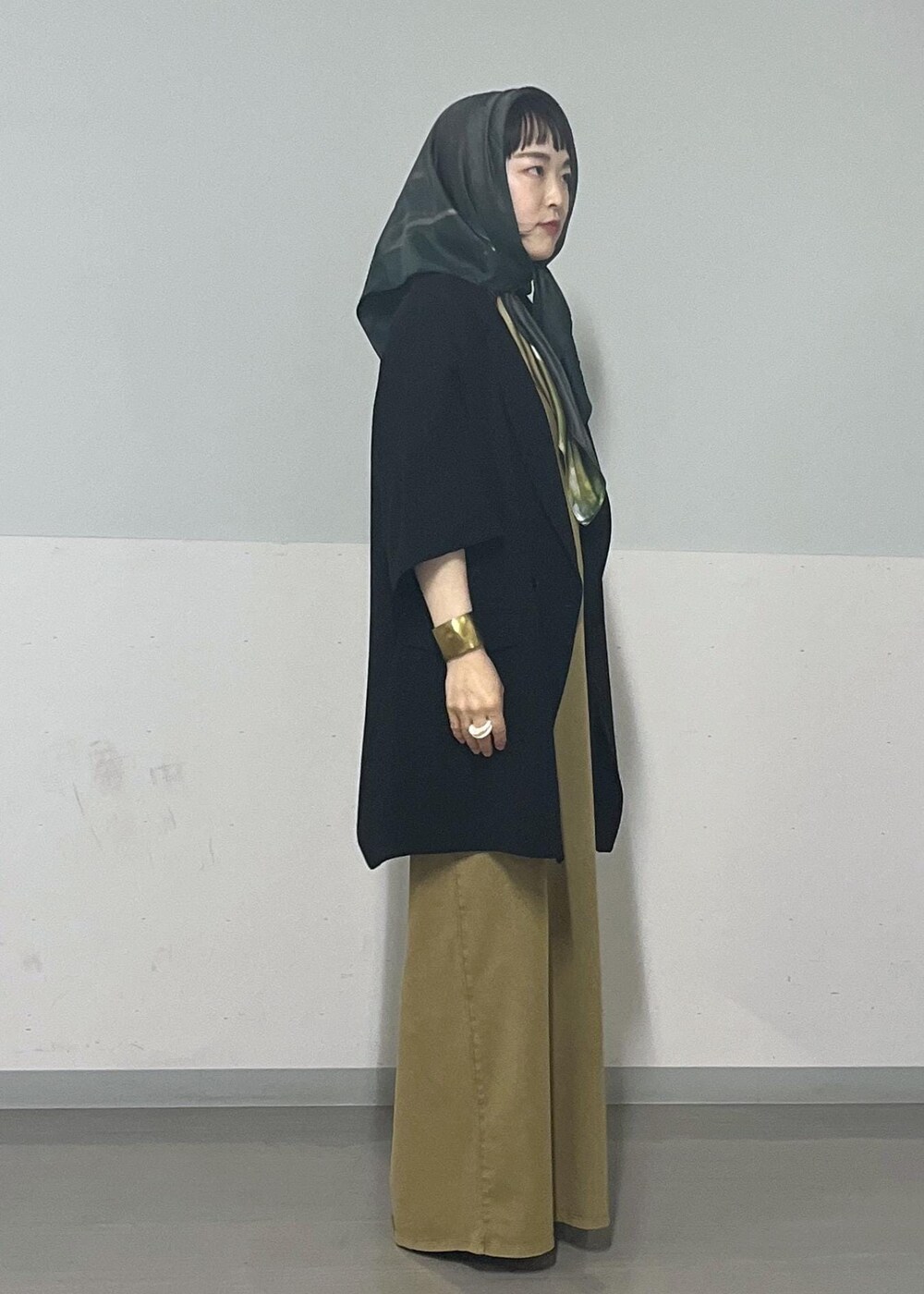 ブラック系のサンダル、ブラック系のテーラードジャケット、ブラウン系のワンピースを着用したレディースの夏コーディネートの4枚目の写真