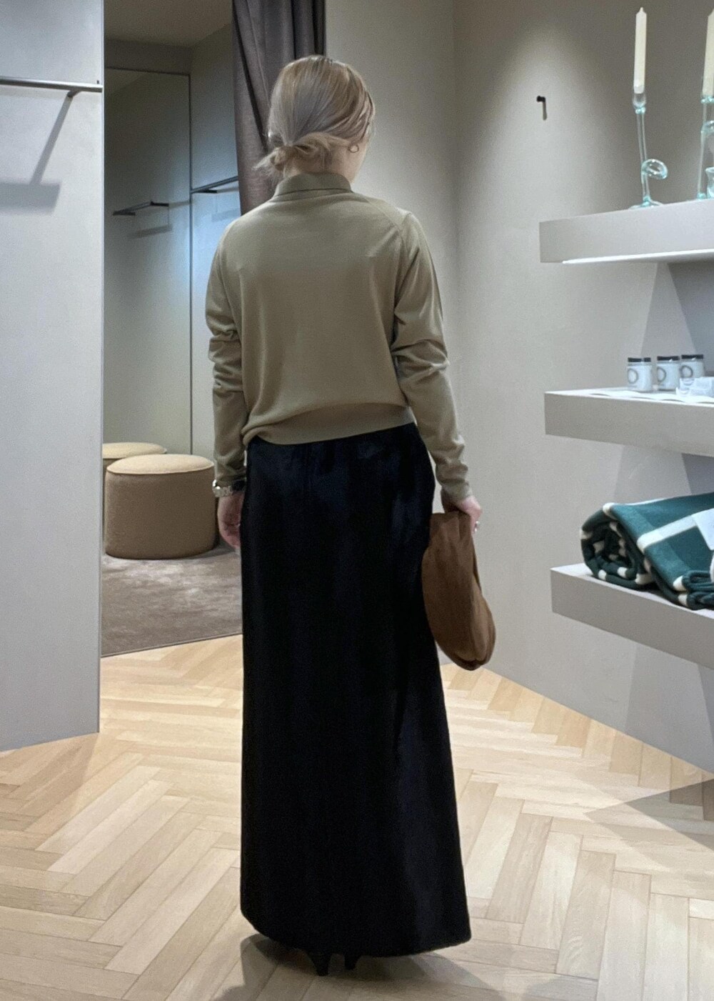 ブラック系のブーツ、ブラック系のスカート、ベージュ系のニット/セーターを着用したレディースの冬コーディネートの3枚目の写真