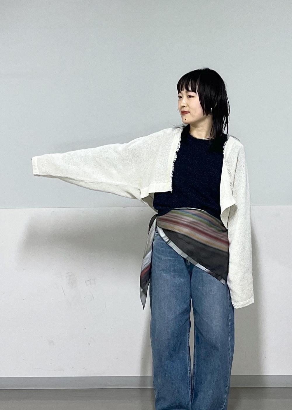 ブラック系のパンプス、ブルー系のデニムパンツ、ホワイト系のカーディガン/ボレロを着用したレディースの冬コーディネートの4枚目の写真