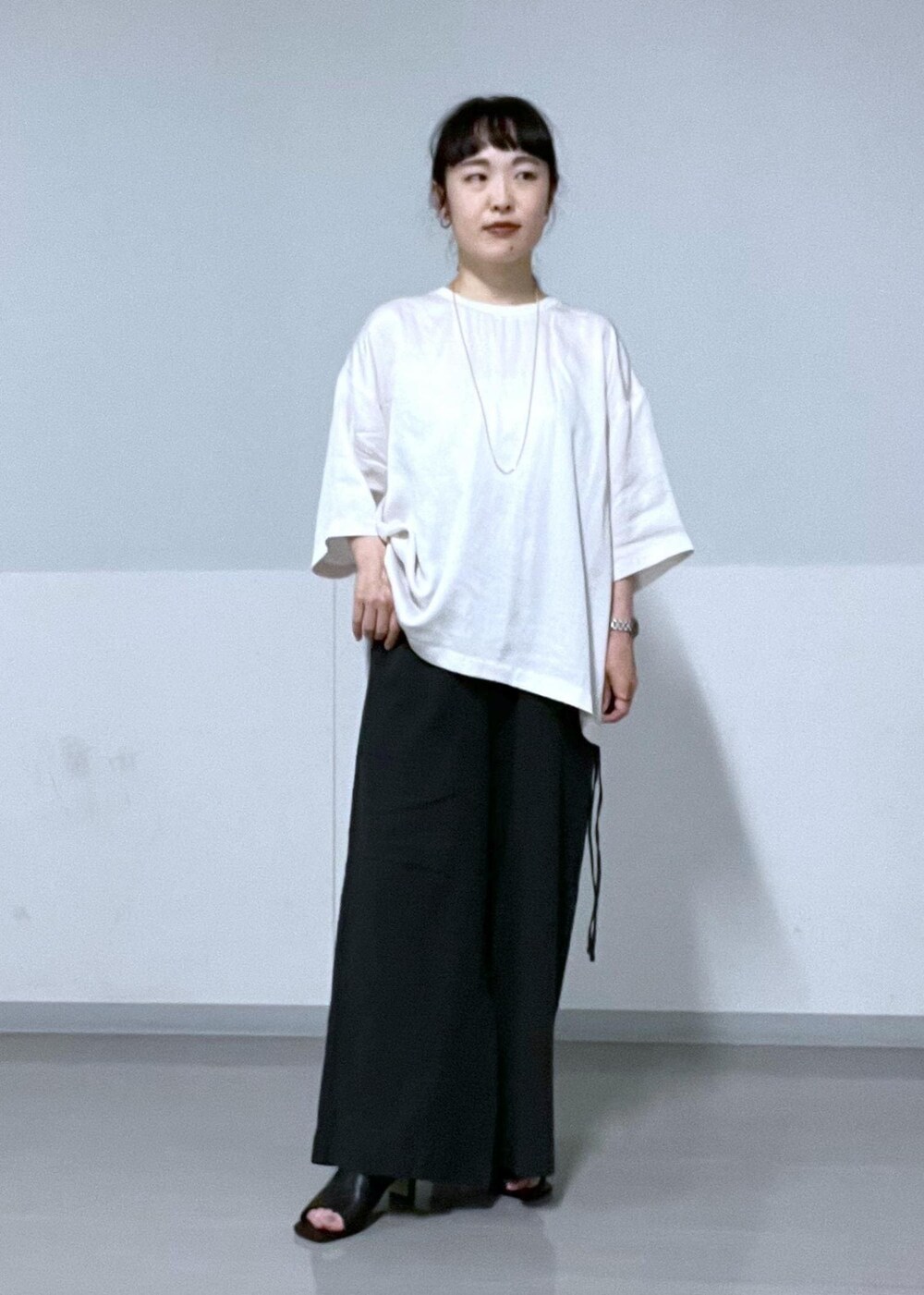 ホワイト系のTシャツ/カットソー、ブラック系のサンダル、ブラック系のその他パンツを着用したレディースの夏コーディネートの2枚目の写真