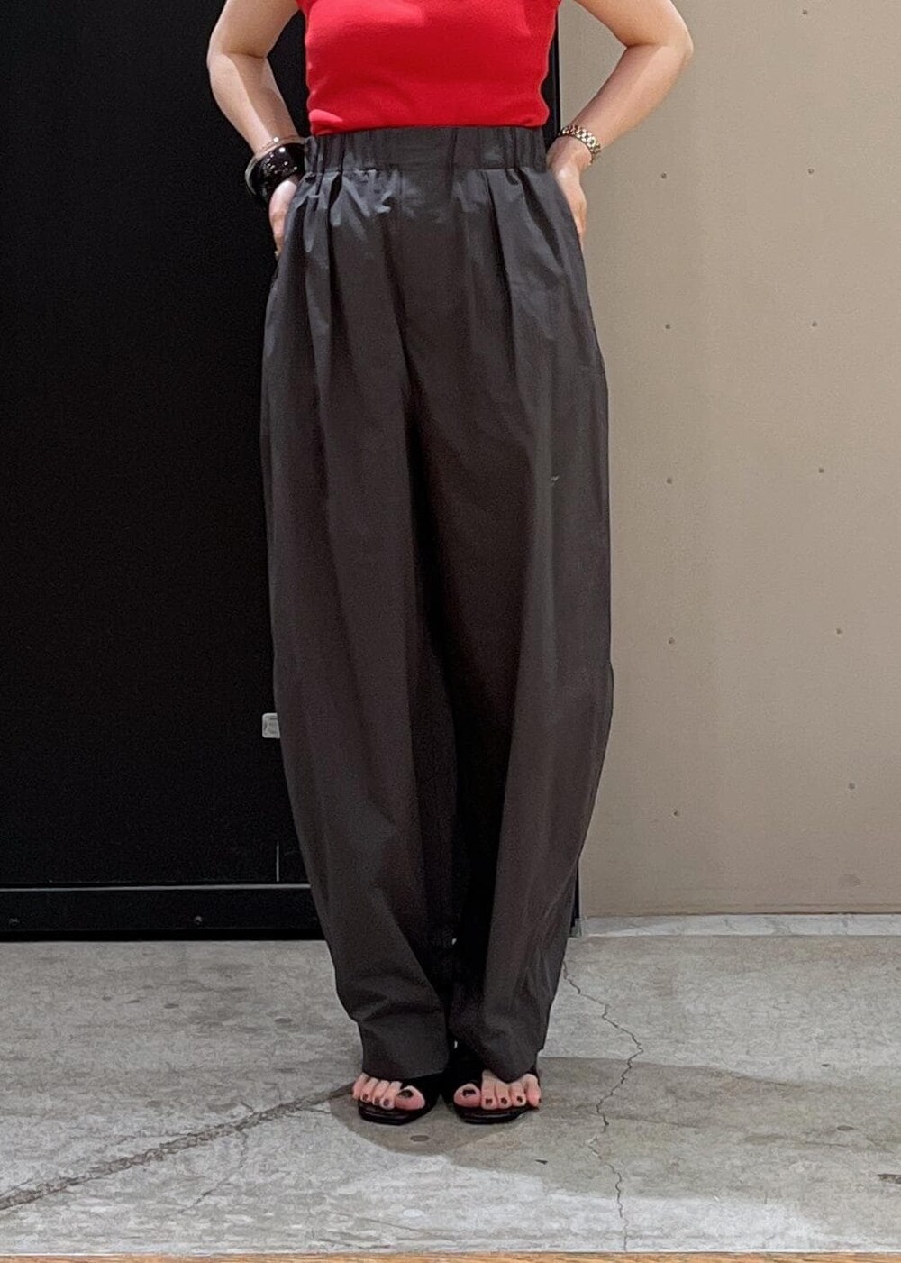 ホワイト系のショルダーバッグ、ブラック系のサンダル、レッド系のタンクトップを着用したレディースの春コーディネートの4枚目の写真