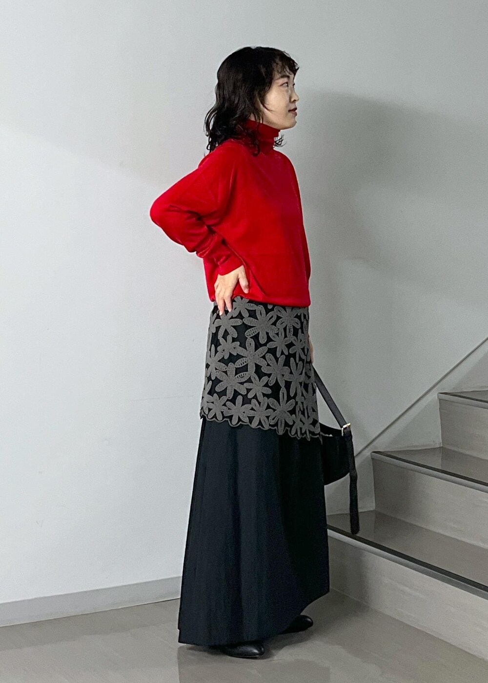 ブラック系のスカート、レッド系のニット/セーター、グレー系のスカートを着用したレディースの秋コーディネートの2枚目の写真