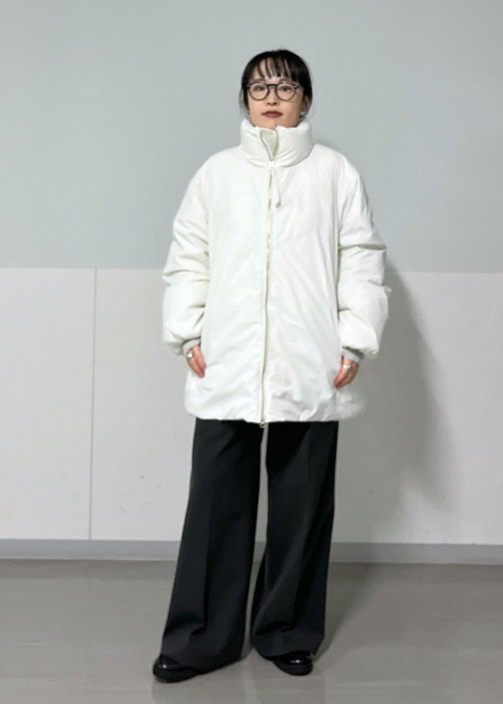 グレー系のその他パンツ、ホワイト系のダウンジャケット/コート、ホワイト系のTシャツ/カットソーを着用したレディースの秋コーディネートの5枚目の写真