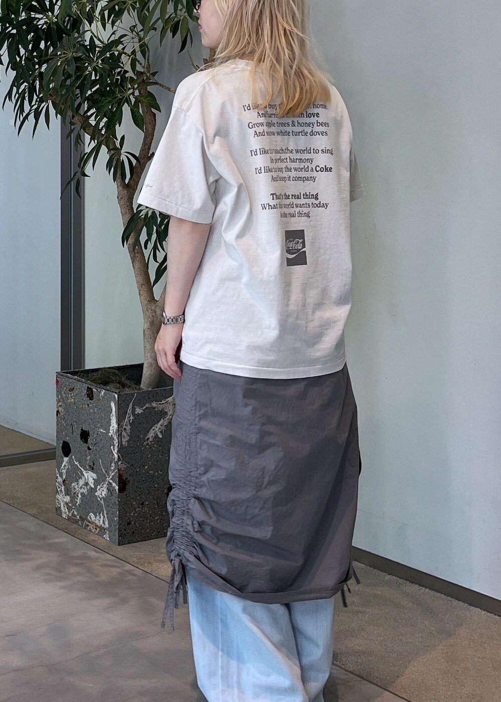 ブルー系のデニムパンツ、グリーン系のパンプス、ブラウン系のショルダーバッグを着用したレディースの夏コーディネートの5枚目の写真